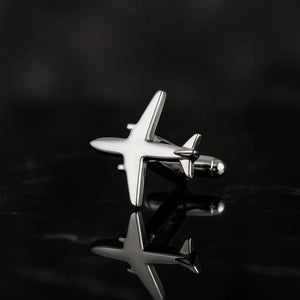 Close-up of silver Pilot Cuff Pin airplane design on black reflective surface.