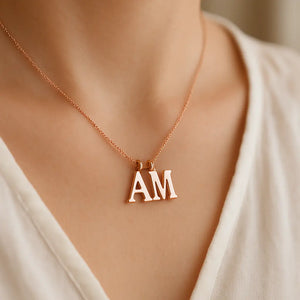 Rose gold dual letter necklace “AM” pendant worn by a woman – personalized initial jewelry