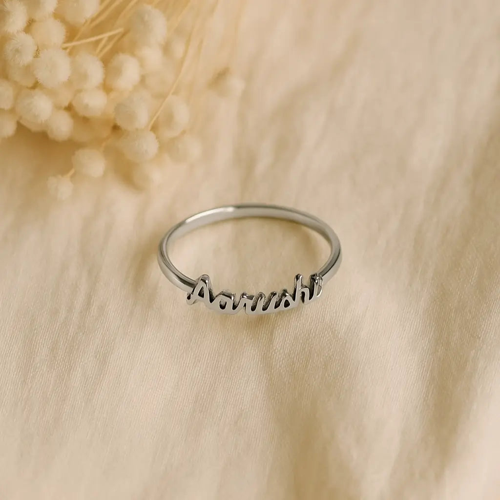 Silver personalized name ring with “Aarushi” text styled on a neutral cloth surface