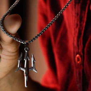 Hand holding a Shiva Trishul pendant necklace on a silver chain, perfect for spiritual wearers