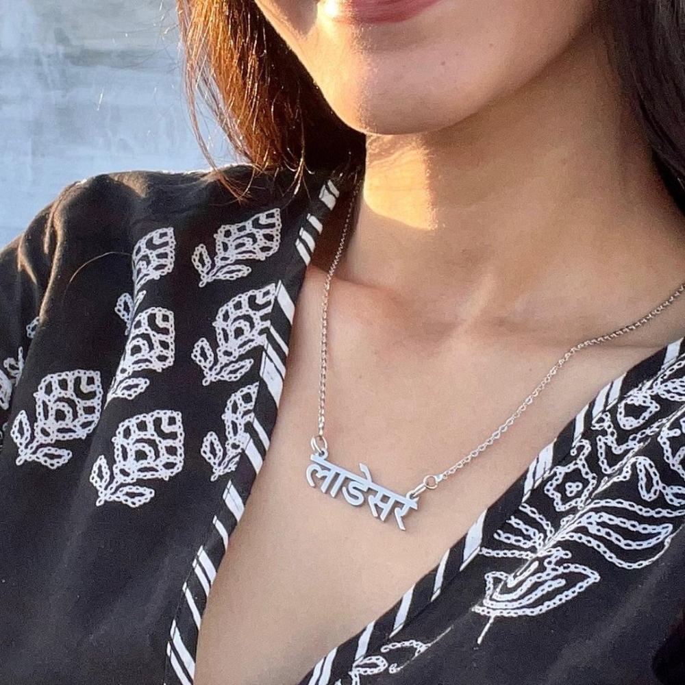 Ankx.in silver Hindi Name Necklace worn by woman with black patterned blouse