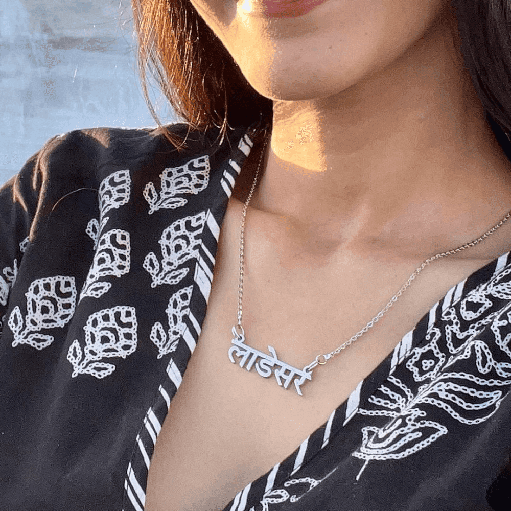 Ankx.in silver Hindi Name Necklace worn by woman with black patterned blouse