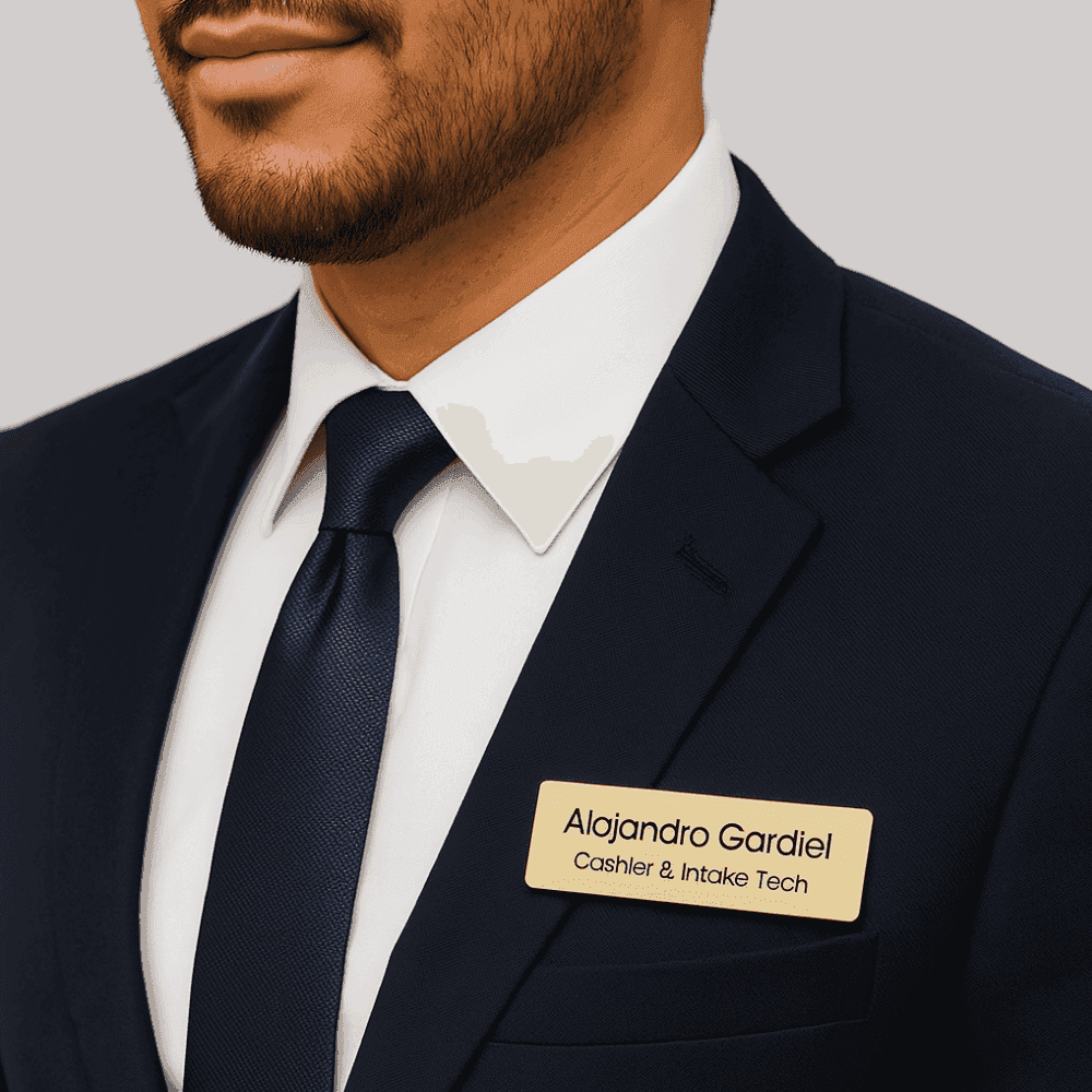 Engraved metal name brooch in gold worn by a professional man in a suit
