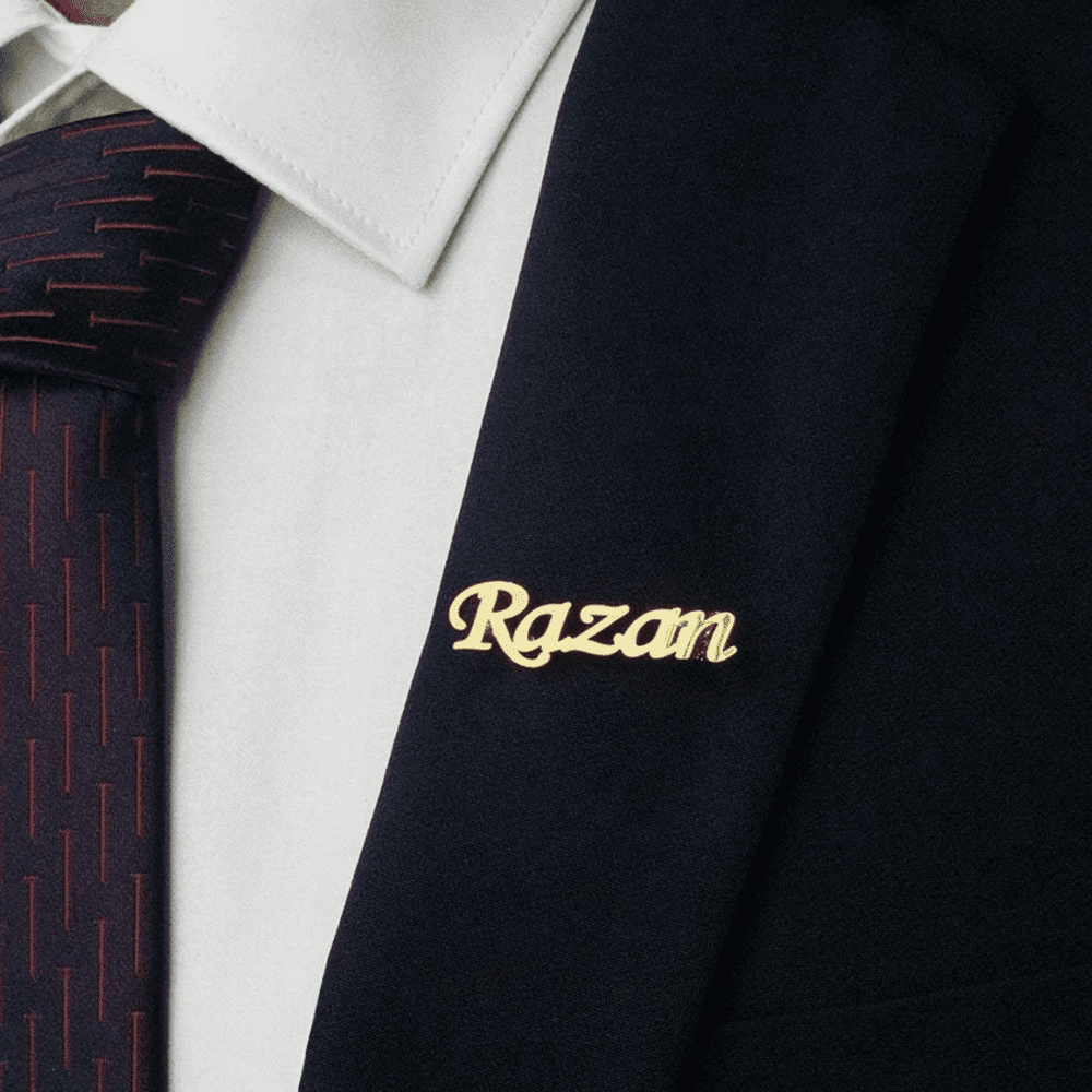 Personalized name lapel pin in gold, worn on a suit jacket for a stylish touch