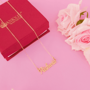 Gold Name Bracelet featuring the name Aishani on a delicate chain against a pink background