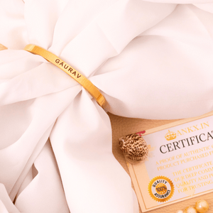 Gold Ankx.in name bracelet with personalized engravings on a soft white fabric backdrop