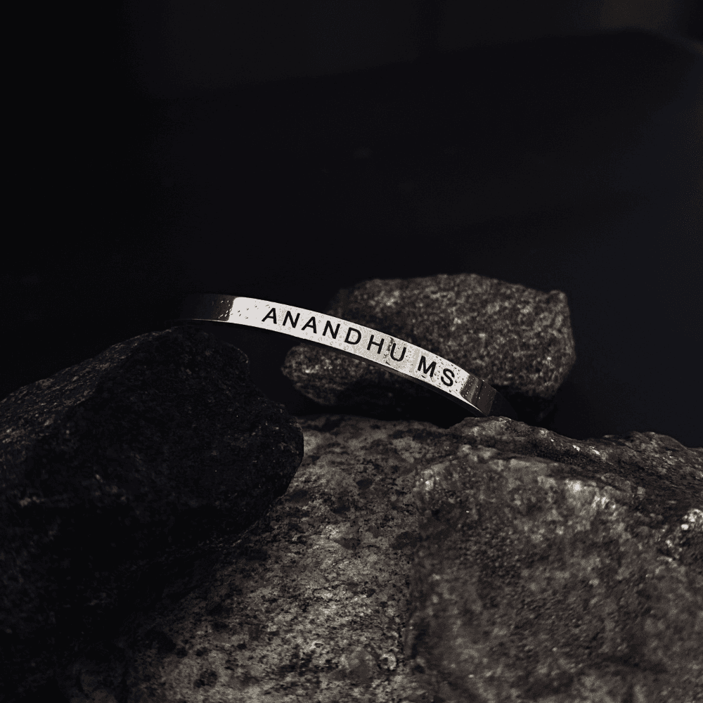 Ankx.in custom silver Name Bracelet with engraved text displayed on natural stone background