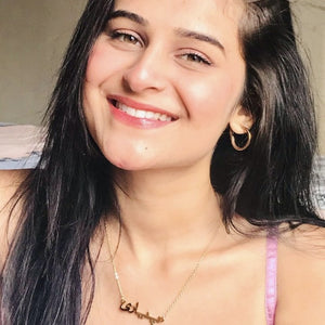 Woman wearing a gold Urdu Name Necklace showcasing custom jewelry from Ankx.in with a smiling face