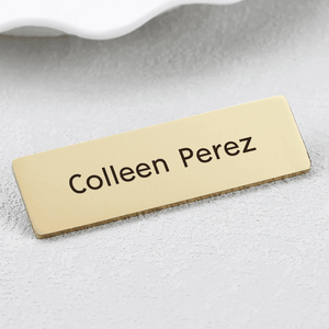 Personalized engraved metal name brooch featuring gold finish with bold lettering for custom styling