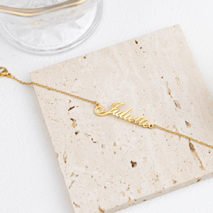 Custom name anklet in gold with Juliette lettering on a textured surface