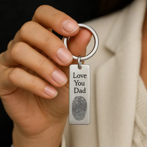 Woman holding a custom fingerprint keychain engraved with message “Love You Dad”