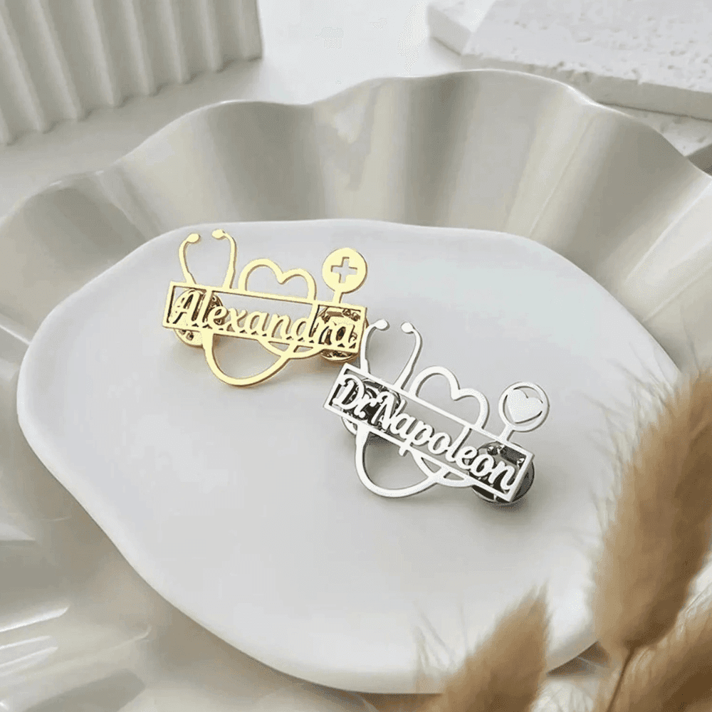 Personalized doctor stethoscope brooch in gold and silver designs on a decorative plate