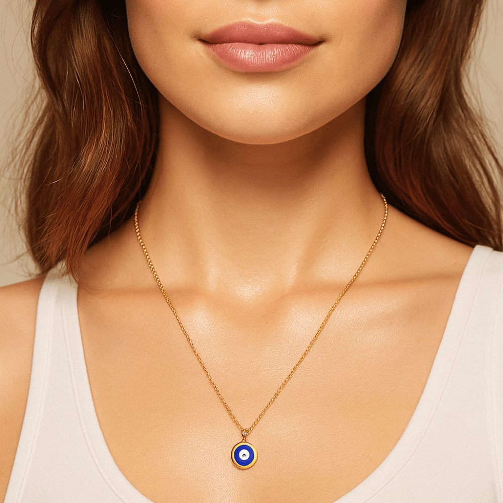 Gold evil eye necklace featuring a blue enamel pendant on a delicate chain