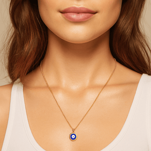 Gold evil eye necklace featuring a blue enamel pendant on a delicate chain