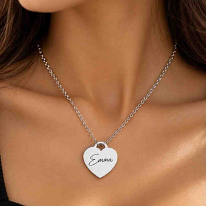 Woman wearing a personalized silver heart necklace engraved with Emma against a black outfit