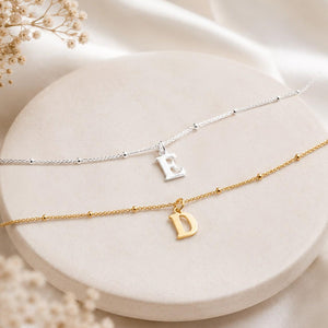 Silver and gold initial anklets with letter E and D charms