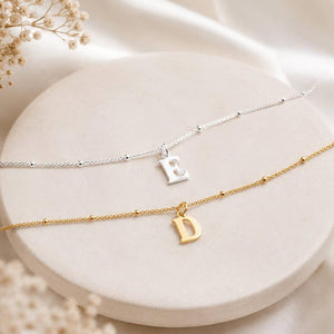 Silver and gold initial anklets with letter E and D charms