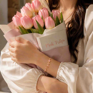 Woman wearing pink crystal Tulip Bracelets while holding tulip bouquet