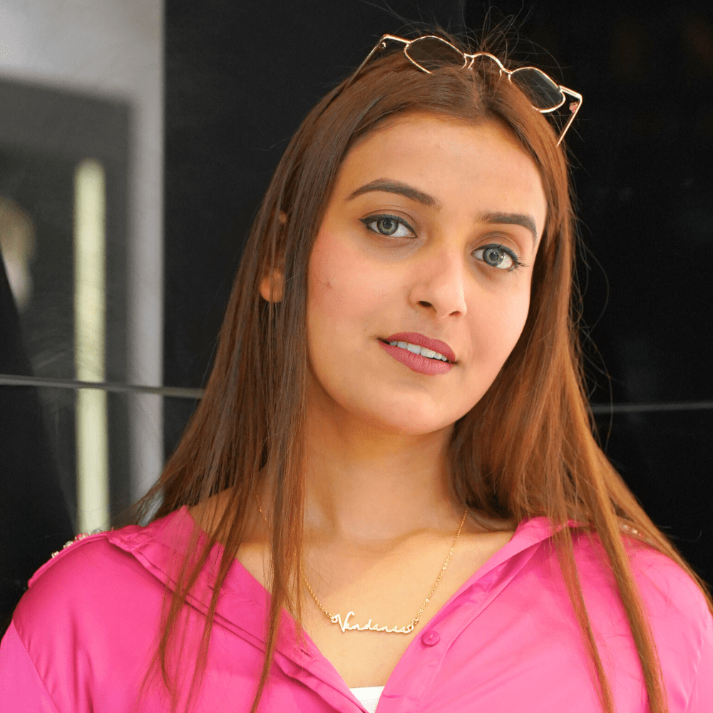 Woman modeling a unique gift custom name jewelry necklace made by Ankx.in in a stylish pink outfit