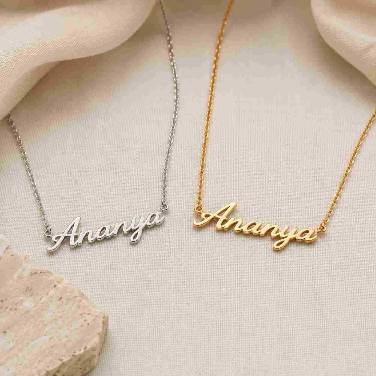 Sterling silver and gold-plated personalized name necklaces displayed side by side on a neutral background