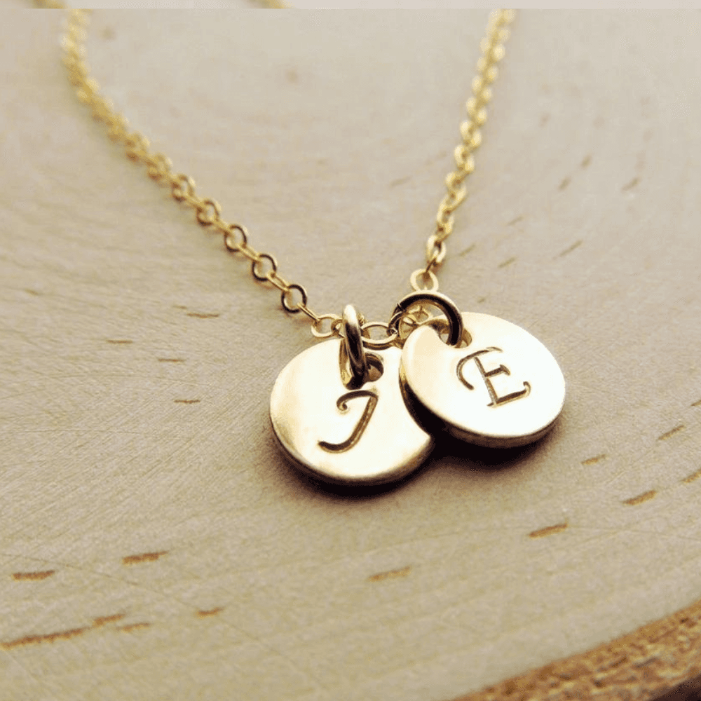 Gold custom jewellery name necklace with two round pendants engraved with initials J and E