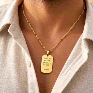 Gold personalized dog tag necklace worn by a man with “Once by my side, forever in my heart” and “Marley” engraved on the pendant.