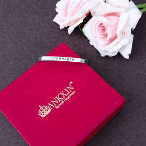 Personalized Silver Name Bracelet engraved with Sidhharth, placed on a premium red ANKX.IN gift box with pink roses.