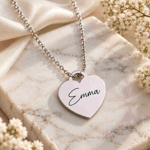 Silver Emma heart necklace displayed on white marble with elegant floral accents
