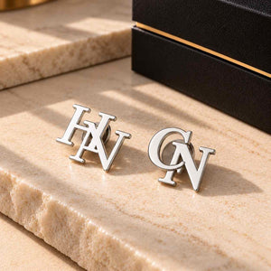 Custom Initial Lapel Pin featuring silver initials HN and CN on a marble surface for personalized style