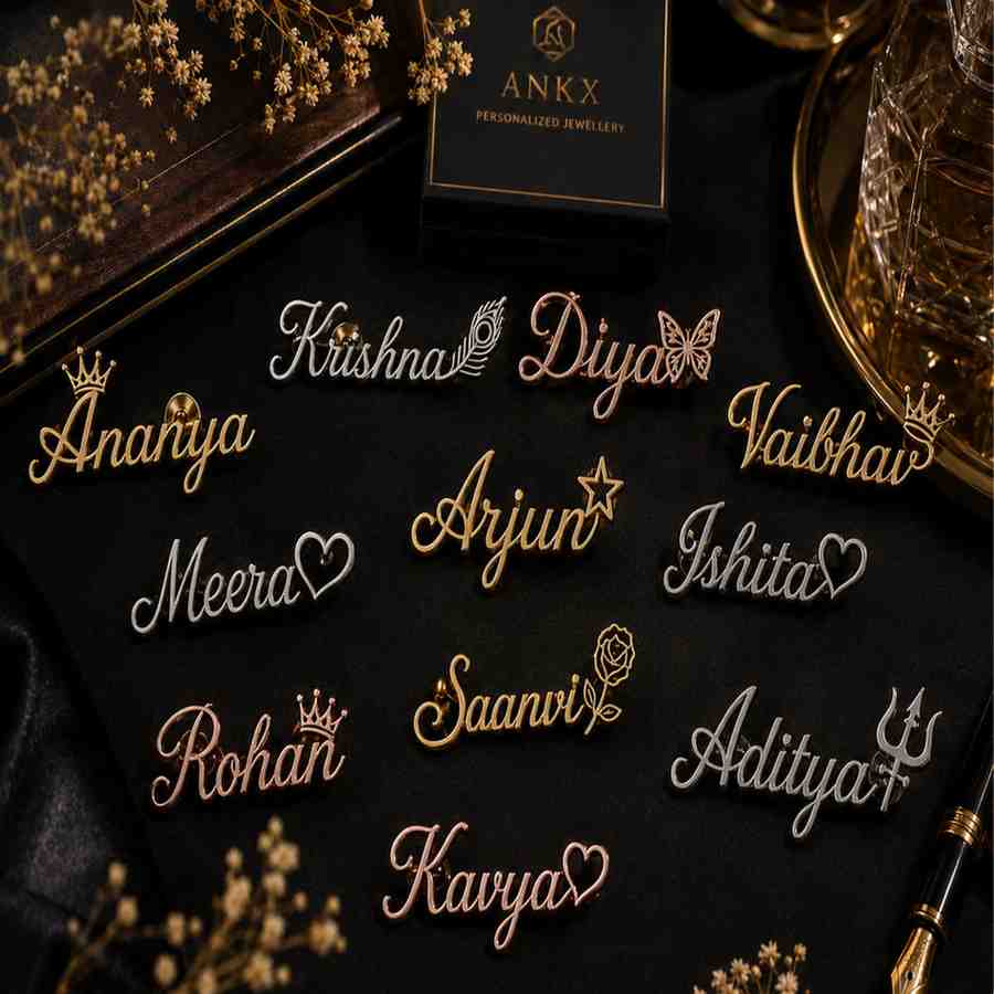 Assorted personalized name pins with charms displayed on a black background.