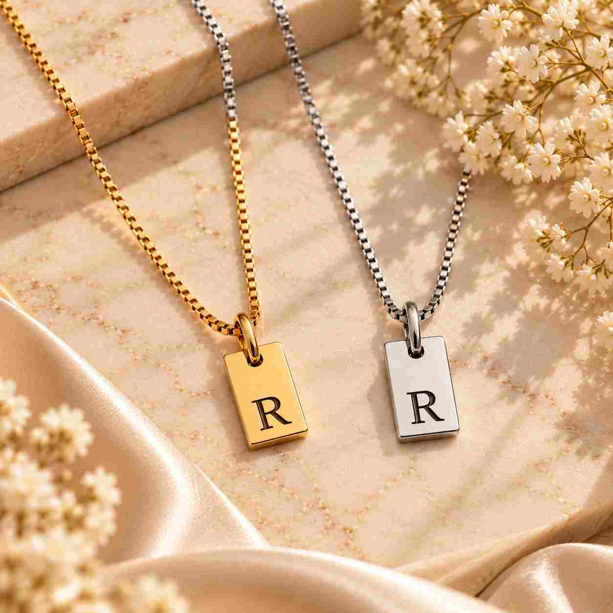 Gold and silver personalized R initial necklaces with black engraved letters displayed together