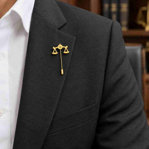 Gold personalized Scales of Justice lapel pin with initial worn on a formal blazer