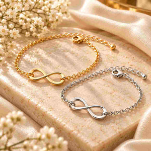 Gold and silver infinity bracelets displayed together on a beige stone surface