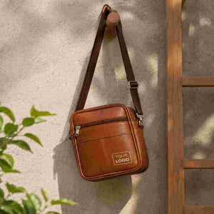 Leather sling bag hanging on wooden hook with adjustable strap