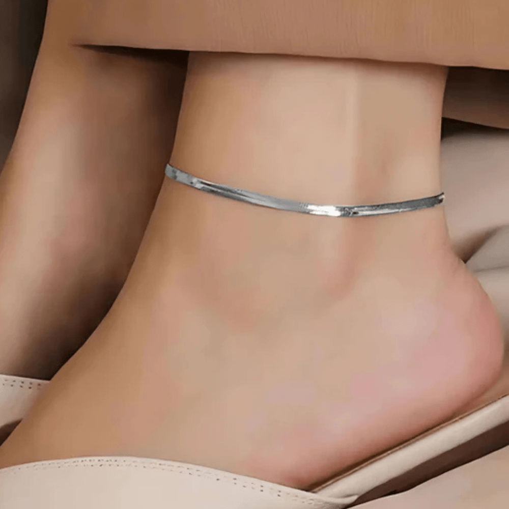 Minimal silver anklet for women showcased elegantly on a bare ankle