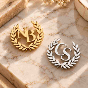 Ankx.in Monogram Lapel Pin in Gold and Silver with Personalized Initials NB and CS set against a marble background
