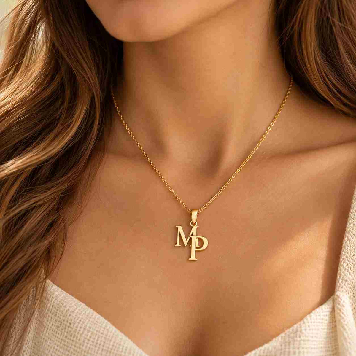 Woman wearing a gold M P personalized initial necklace on her collarbone