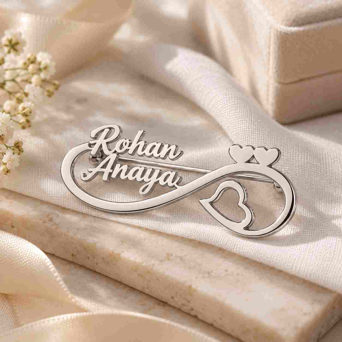 Personalised Couple Name Brooch featuring Rohan and Anaya in silver with heart and infinity design