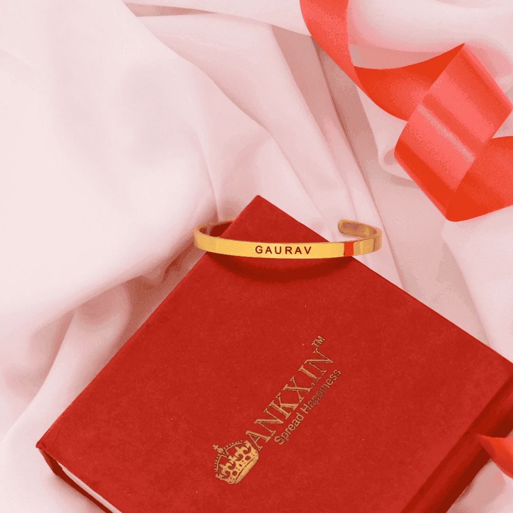 Personalised name bracelet by Ankx.in displayed on a red gift box with a ribbon