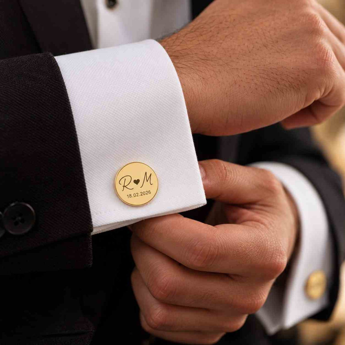 Personalized gold initial cufflinks with couple initials and wedding date on groom's shirt cuff