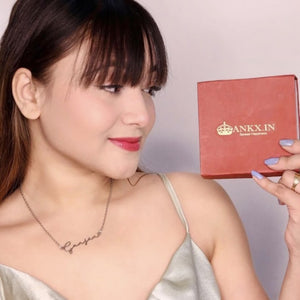 Personalized name necklace combo displayed on a model holding an Ankx.in gift box