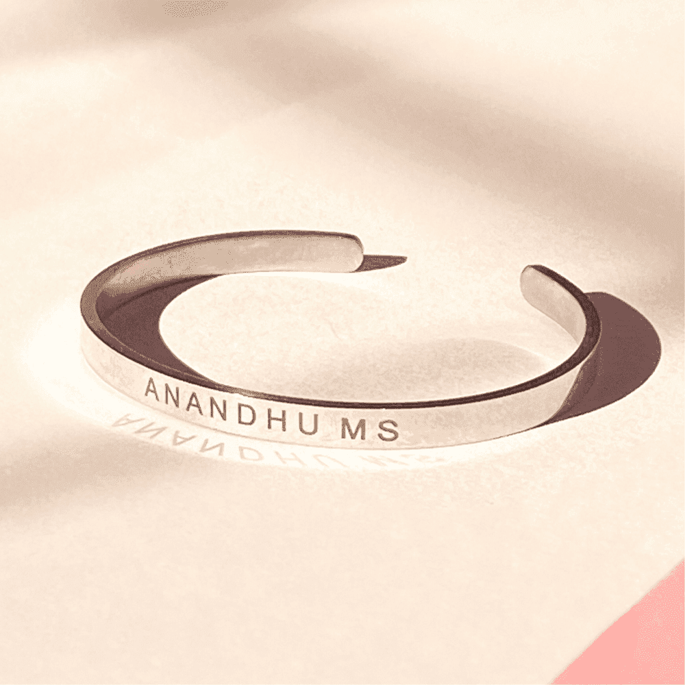 Custom Silver Name Bracelet engraved with Anandhu MS in a minimalist cuff design.