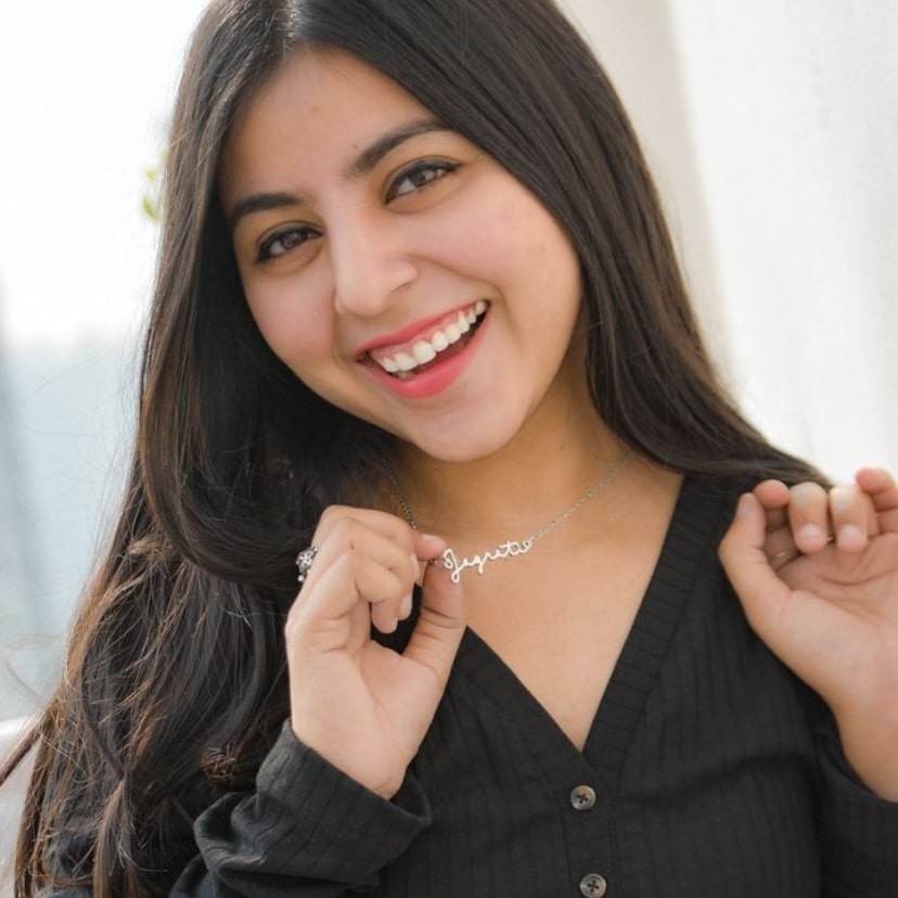 Woman smiling while wearing a Silver name Necklace showcasing her name beautifully