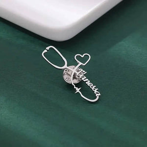 Silver stethoscope brooch with custom name and heart charm on green background